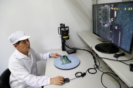 06刘文清院士在航天载荷电装间，使用高清晰检测设备审查电路板电装质量.png