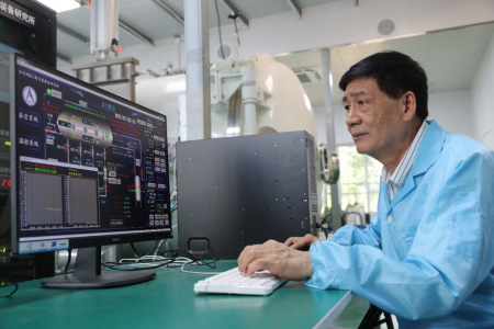 09刘文清院士在环境光学中心的真空环境模拟实验室认真观察真空设备的运行工作状态.png